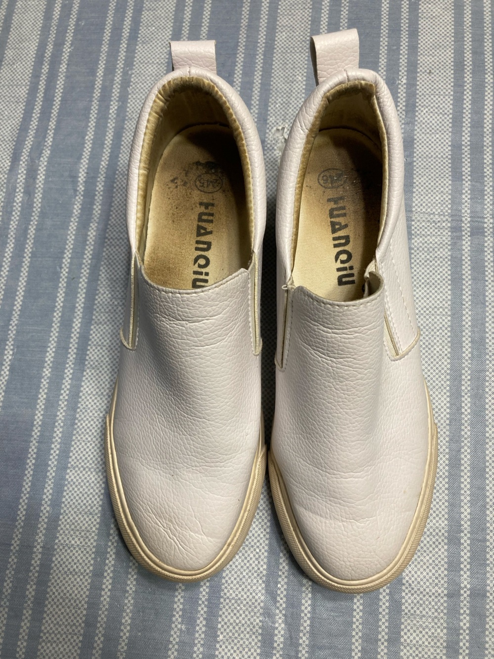 Guansitu off-white slip on sneakers.